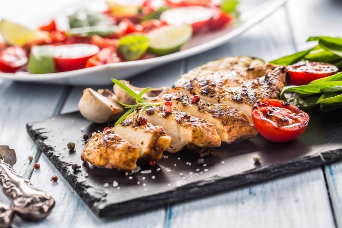 Sliced grilled chicken breast with tomatoes and mushrooms
