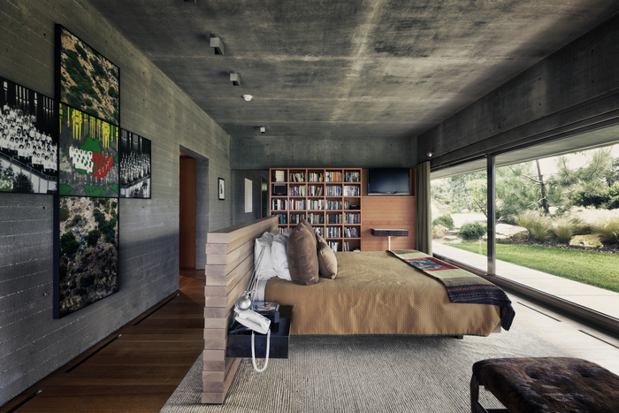 Modern bedroom with concrete walls and large window