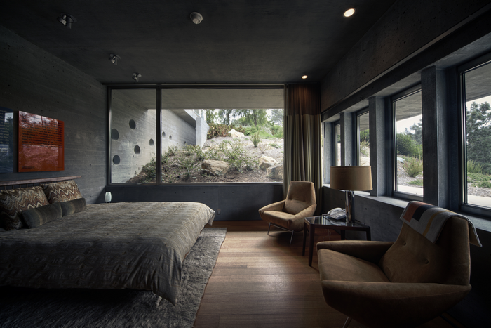 Modern bedroom with concrete walls and large windows