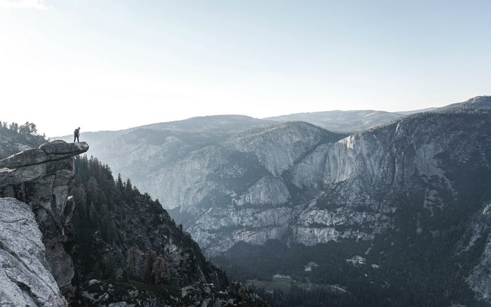 Hiker on a cliff overlooking Yosemite Valley