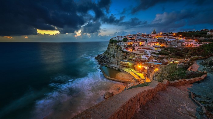 Coastal village on a cliff overlooking the sea at dusk