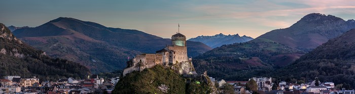 4K castle on a hill with mountains and town
