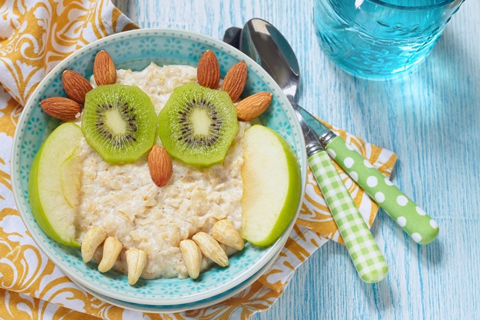 Owl-shaped oatmeal with kiwi, almonds, and apples