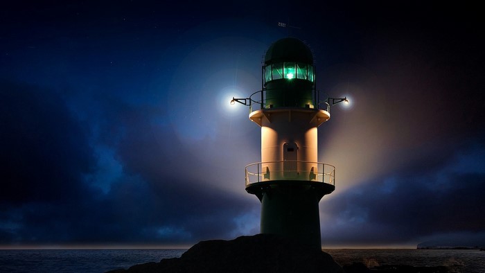 Lighthouse at night on the sea coast