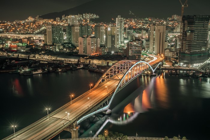 Night cityscape of Busan with a bridge over water