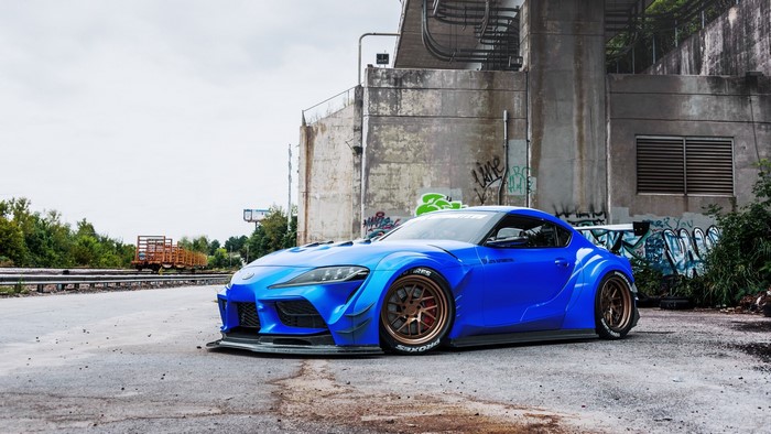 Blue widebody Toyota Supra with bronze wheels
