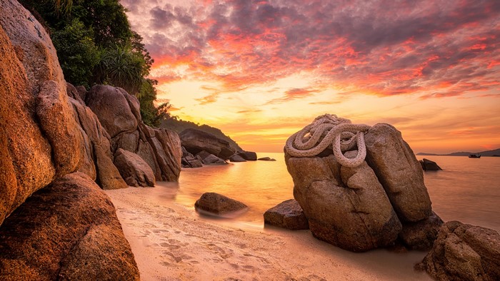 Beach with rocks and sunset sky
