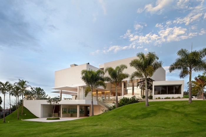 Modern white house with palm trees and green lawn