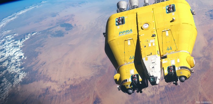 Yellow spaceship in orbit above a planet