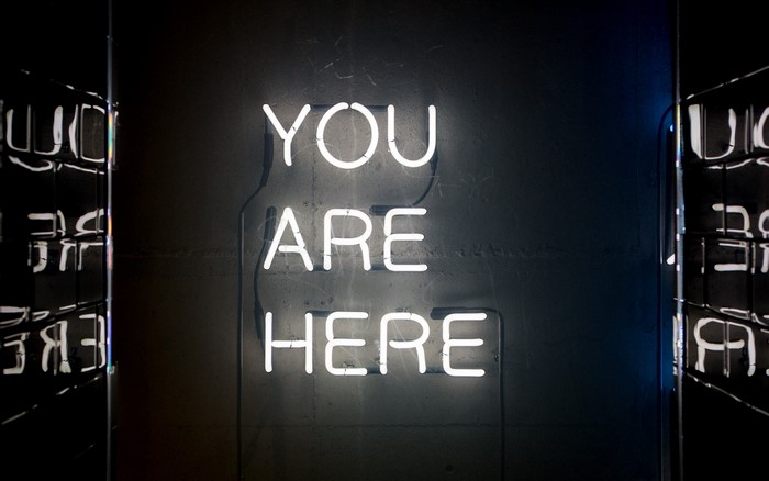 Neon sign that says "YOU ARE HERE"