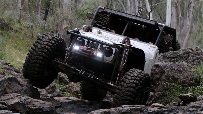 Off-road vehicle climbing rocks in a forest