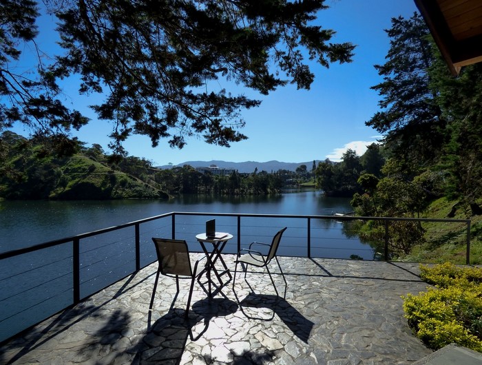 Balcony overlooking a lake with chairs and table