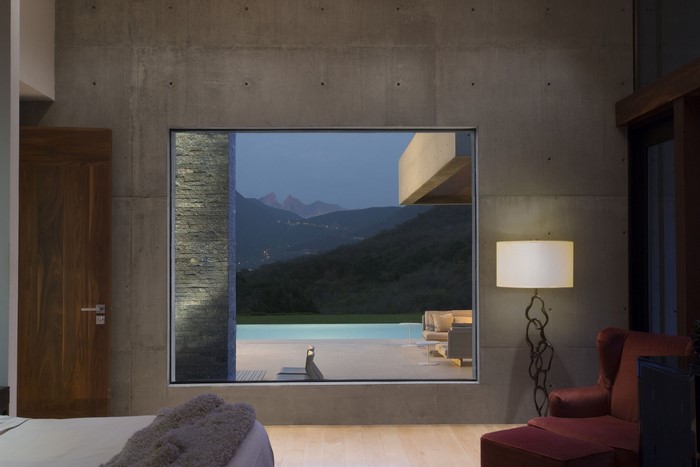 Modern room with large window overlooking mountains and pool