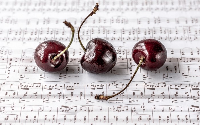 Three cherries on sheet music