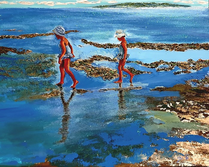 Two girls walking on a beach with reflections