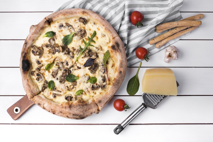 Mushroom pizza with tomatoes, garlic, cheese, and breadsticks