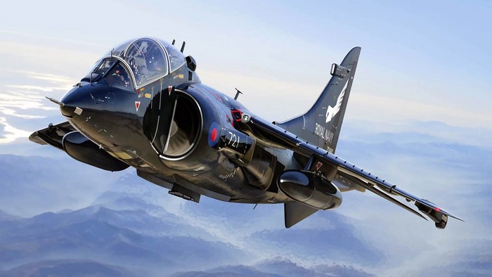 Black Royal Navy Harrier Jump Jet flying over mountains