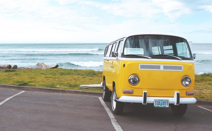 Yellow Volkswagen Van parked by the ocean