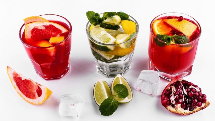 Three glasses of fruit drinks with garnishes