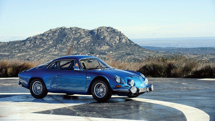 Blue Renault Alpine car on a scenic mountain road