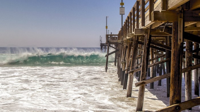 Wooden pier over the ocean with large waves