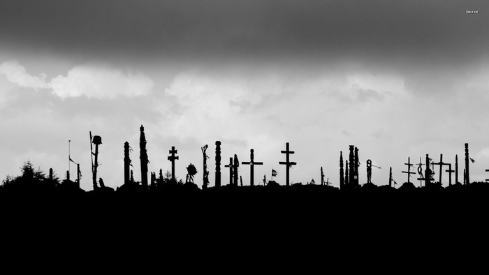 Silhouette of crosses and monuments against a cloudy sky