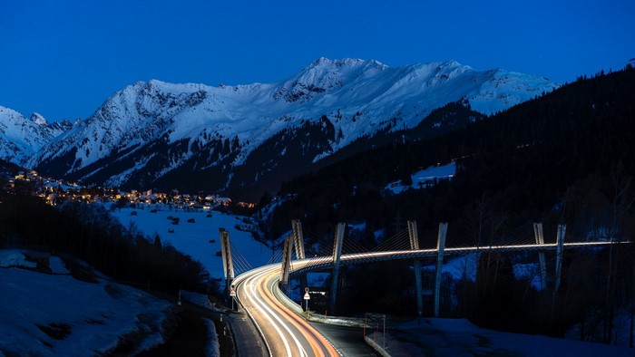 Night view of a snowy mountain village and a viaduct in Switzerland