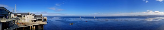 Panoramic view of a waterfront with buildings and sailboats