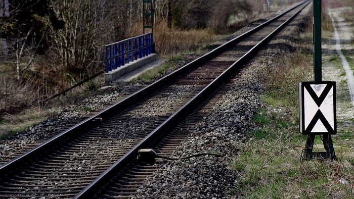 Railway tracks with a signal post and bridge