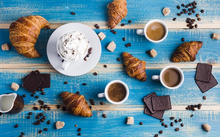 Croissants and coffee with chocolate and sugar cubes
