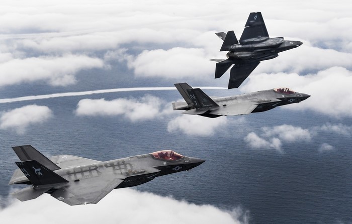 Three F-35 fighter jets flying over the ocean