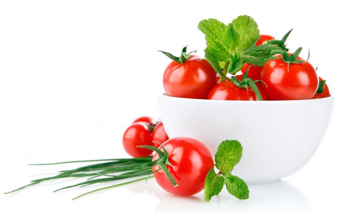 Tomatoes and mint in a white bowl with chives