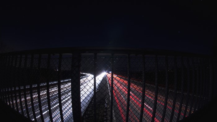 Long exposure of highway at night with fence