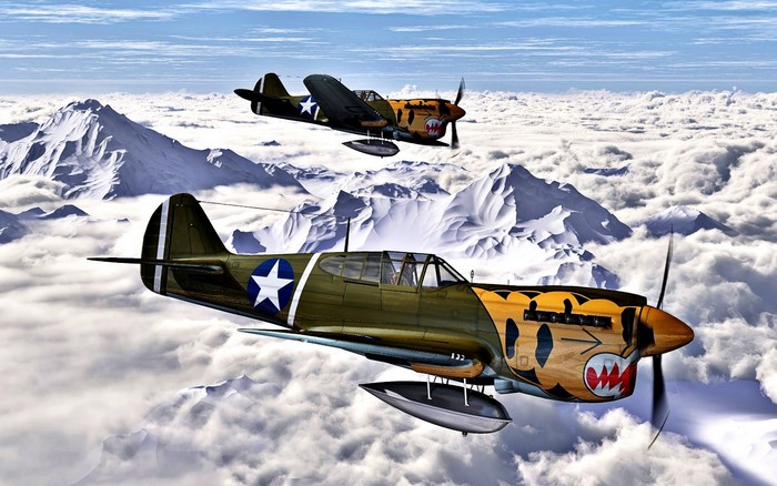 Two Curtiss P-40 Warhawk aircraft flying over mountains