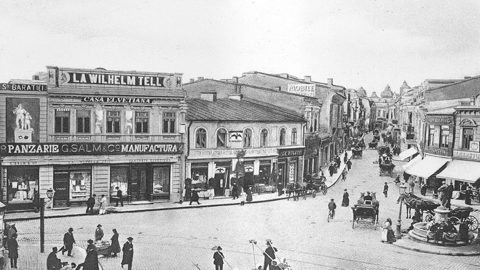 Street scene in Bucharest, Romania with shops and horse-drawn carriages