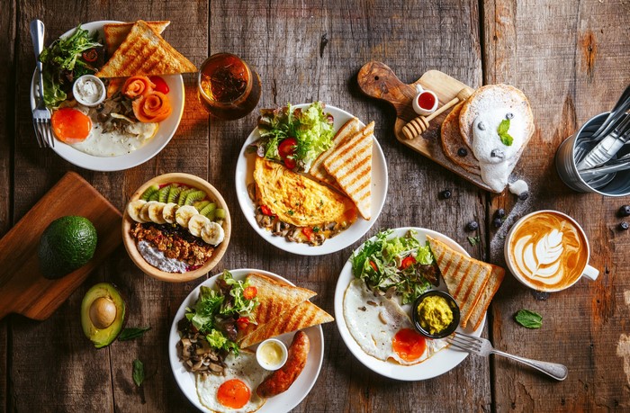 Breakfast spread with eggs, omelets, toast, fruit, and coffee