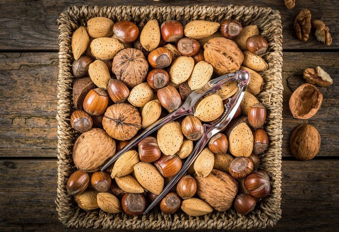 Basket of nuts with a nutcracker on a wooden surface