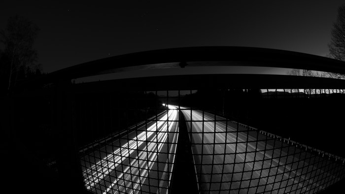Long exposure of highway at night with fence