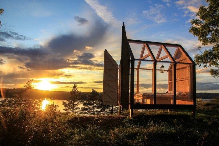 Modern cabin by a lake at sunset