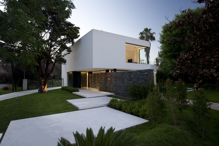 Modern white house with stone wall and large windows