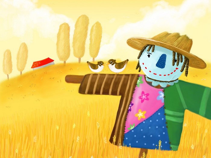 Scarecrow with birds in a wheat field