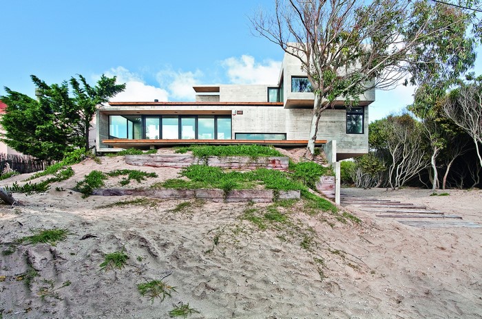 Modern concrete house on a sandy dune
