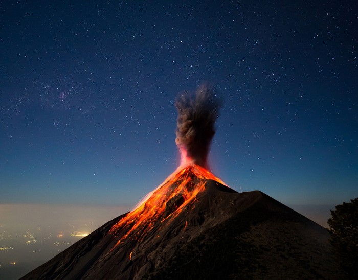 Volcano erupting under a starry night sky in Guatemala