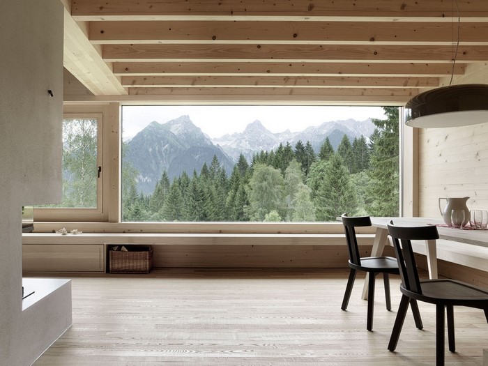 Interior with large window overlooking mountains and forest