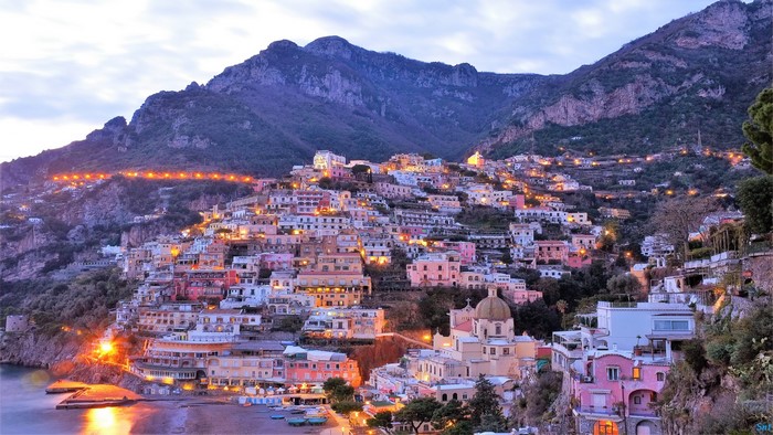 Positano village on a mountainside overlooking the sea at dusk