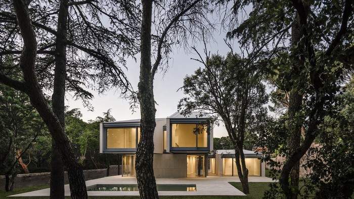 Modern house with swimming pool surrounded by trees