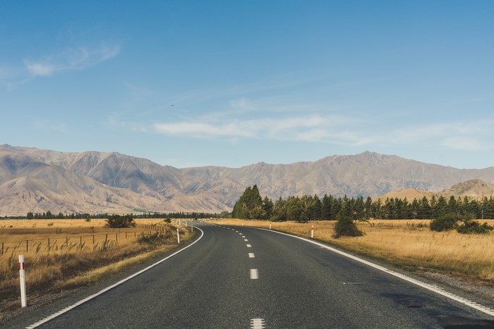 Road through New Zealand landscape with mountains