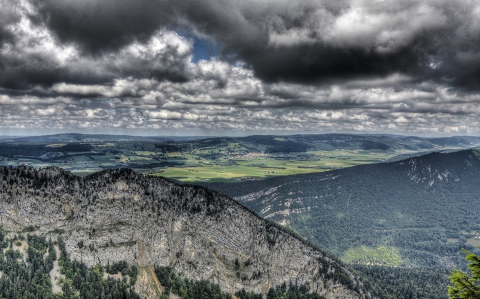 Overcast sky above rolling green hills and mountains