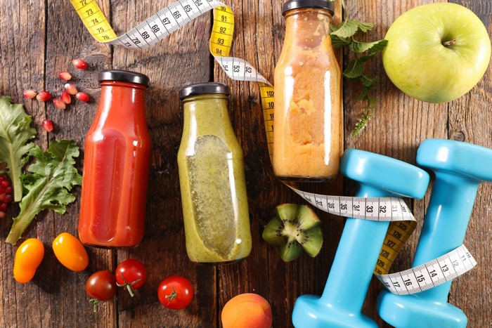 Healthy food and fitness equipment on wooden surface