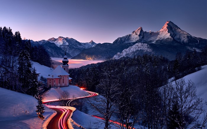 Winter church and mountains with light trails